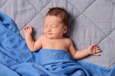 Photo of Adorable newborn baby sleeping under blue blanket on bed, top view