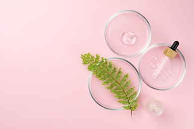 Petri dishes with fern leaf and cosmetic products on pink background, flat lay. Space for text