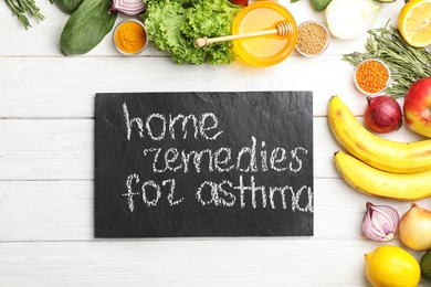 Natural products and slate board with text HOME REMEDIES FOR ASTHMA on wooden background, flat lay