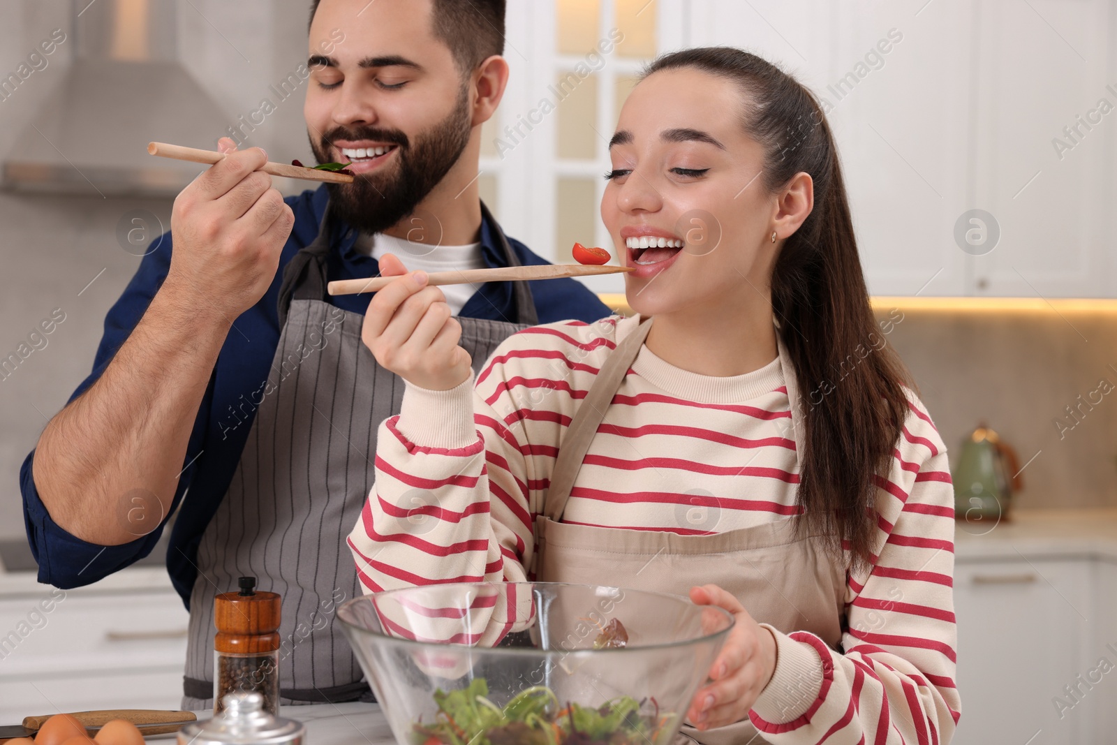 Photo of Happy lovely couple cooking together in kitchen