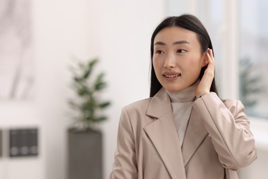 Portrait of smiling businesswoman in office. Space for text