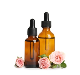 Photo of Bottles of rose essential oil and flowers isolated on white
