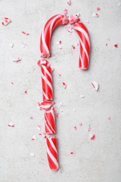 Photo of Crushed Christmas candy cane on grey background, flat lay
