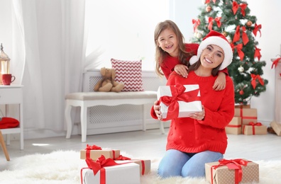 Happy mother and child with gifts celebrating Christmas at home
