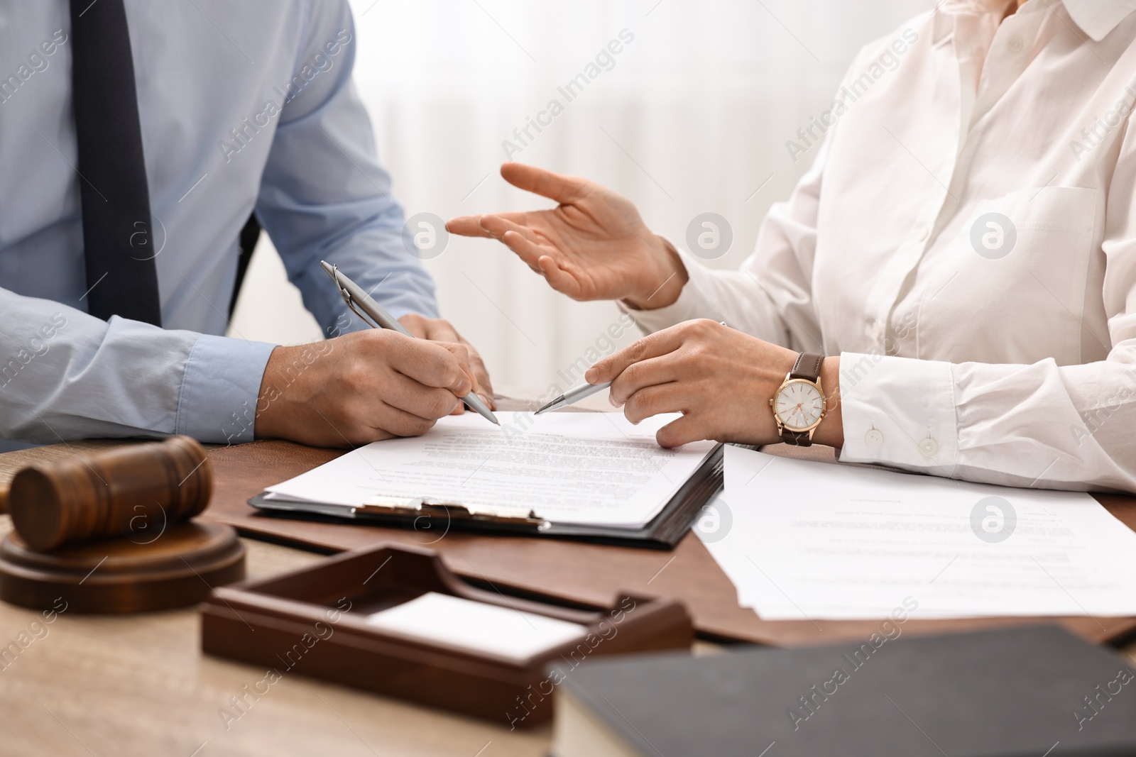 Photo of Lawyers working with documents at table in office, closeup