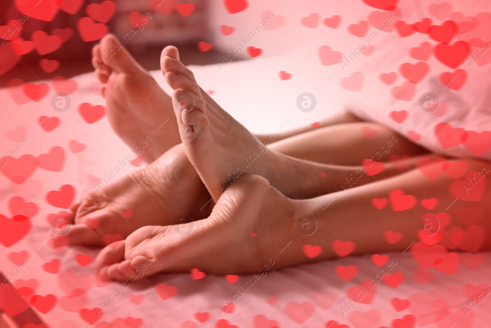 Image of Illustration of hearts and passionate young couple having sex on bed at home, closeup of legs