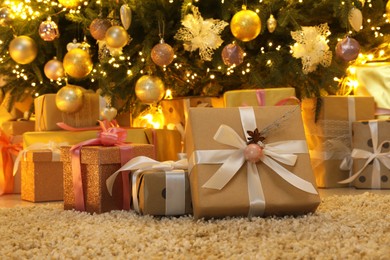Many gift boxes under decorated Christmas tree at home