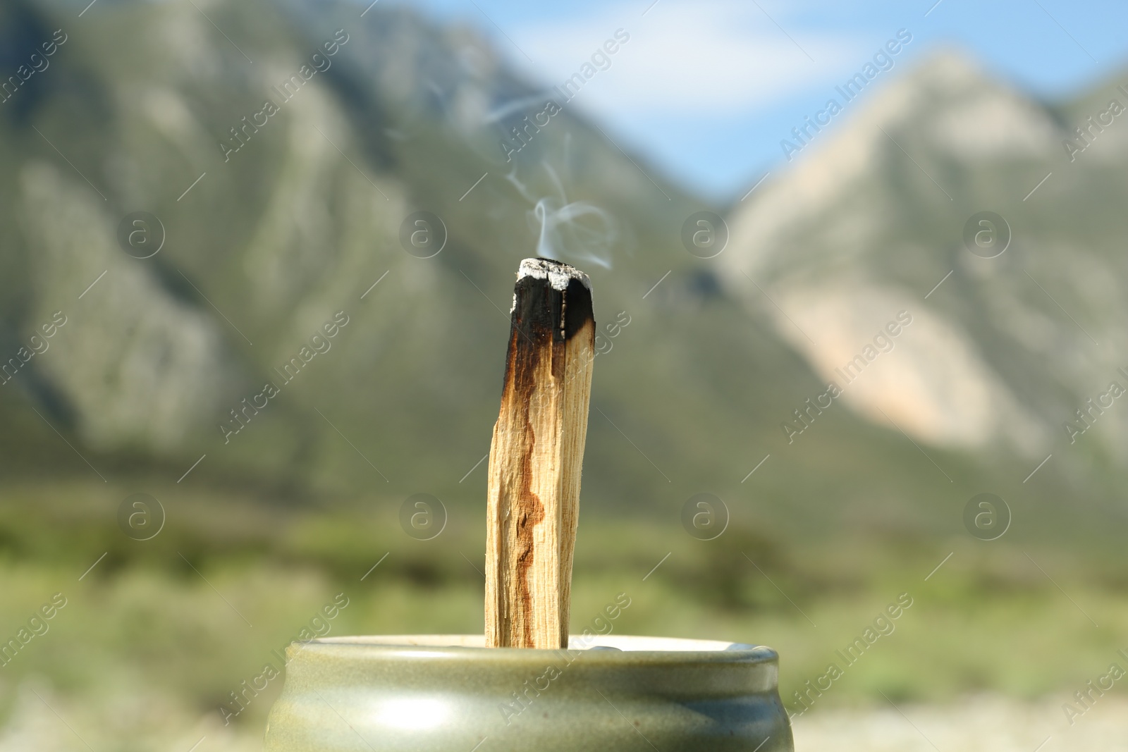 Photo of Burning palo santo stick in high mountains, closeup