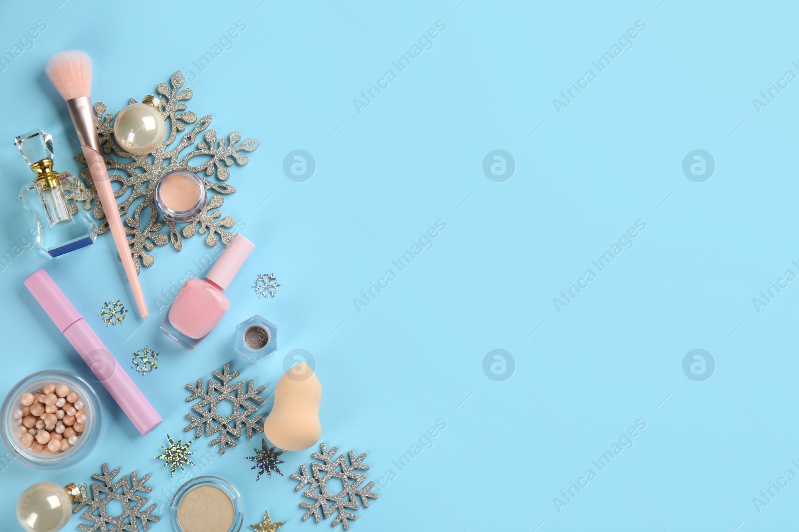 Photo of Flat lay composition with decorative cosmetic products on light blue background, space for text. Winter care