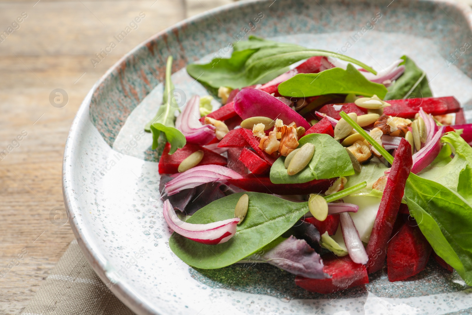 Photo of Plate with delicious beet salad on table, closeup