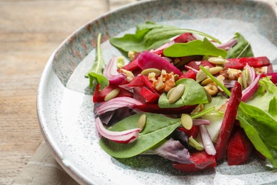 Plate with delicious beet salad on table, closeup