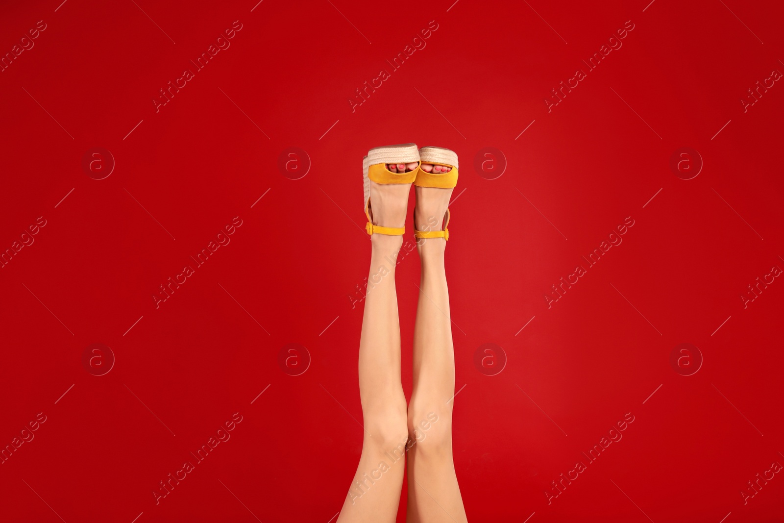 Photo of Woman in stylish shoes on red background