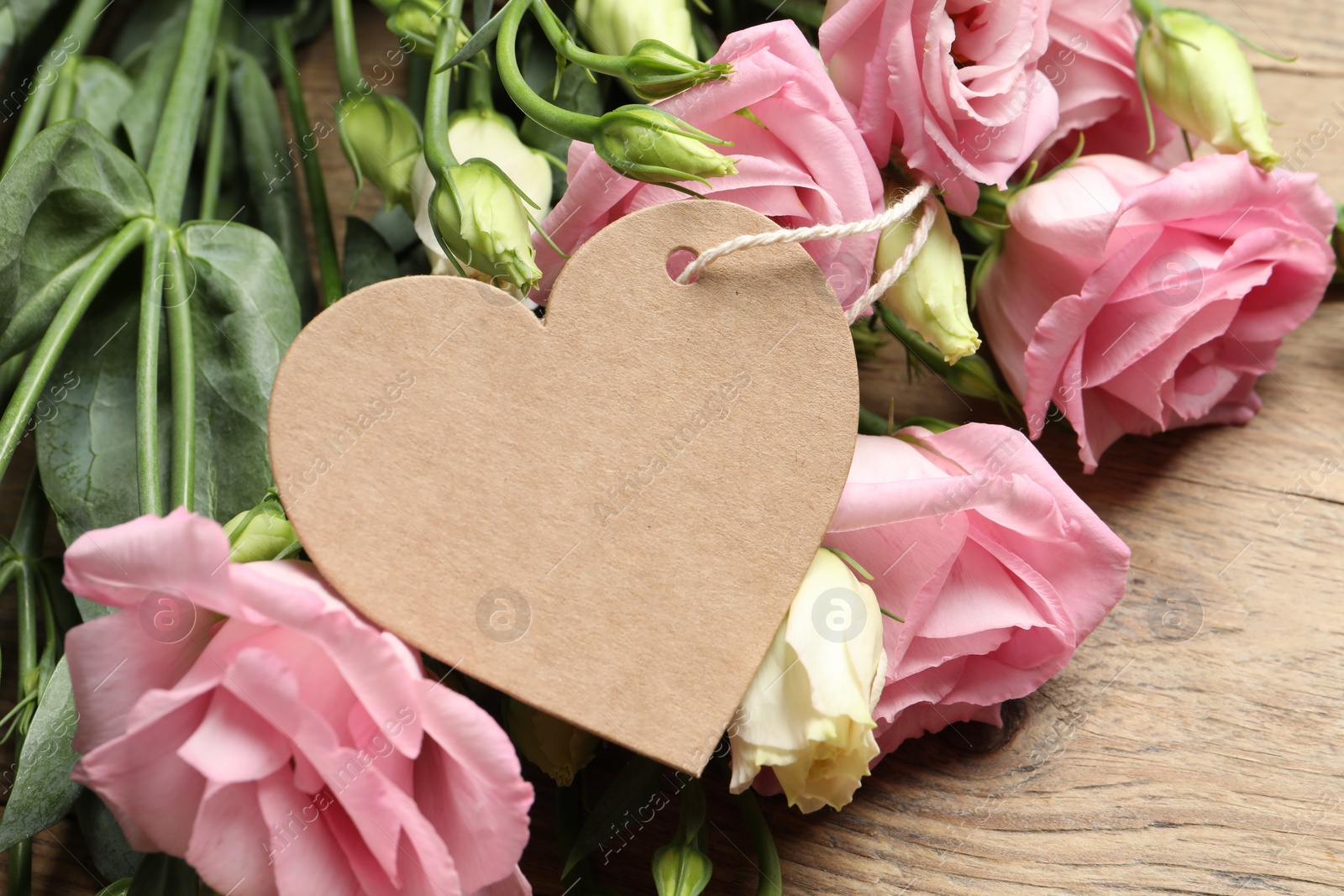 Photo of Happy Mother's Day. Beautiful flowers and blank heart shaped card on wooden table, closeup