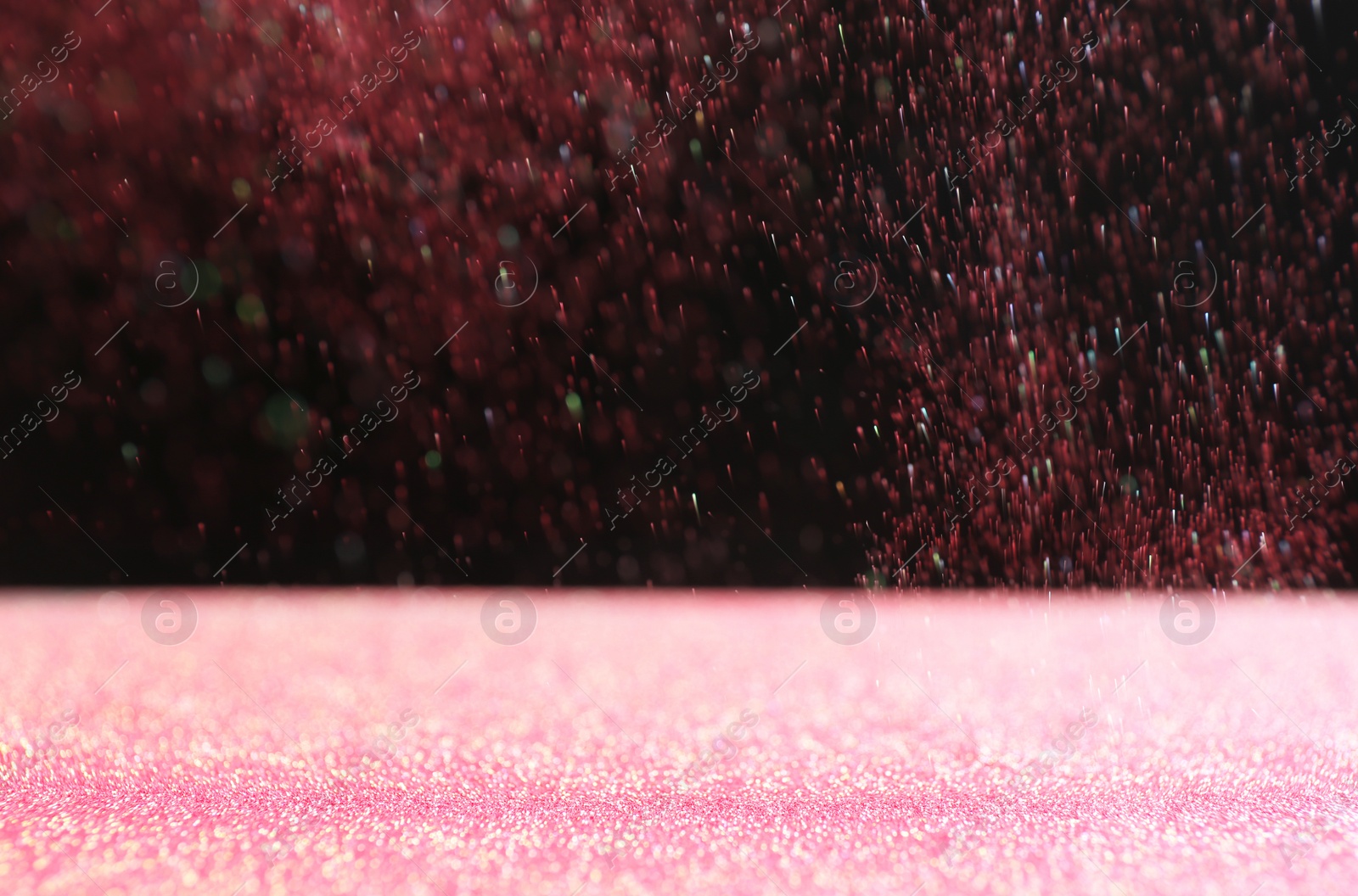 Photo of Glitter on table against dark background. Bokeh effect