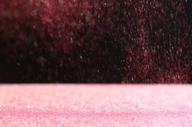 Photo of Glitter on table against dark background. Bokeh effect