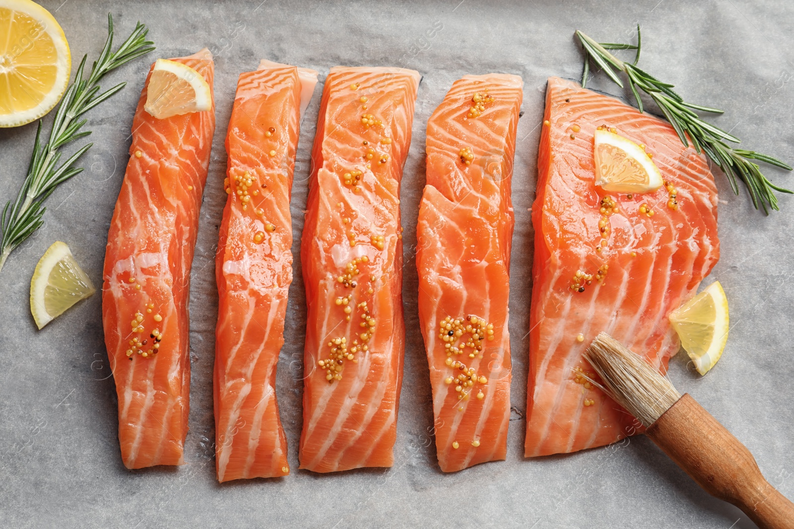 Photo of Fresh salmon with mustard on parchment, top view