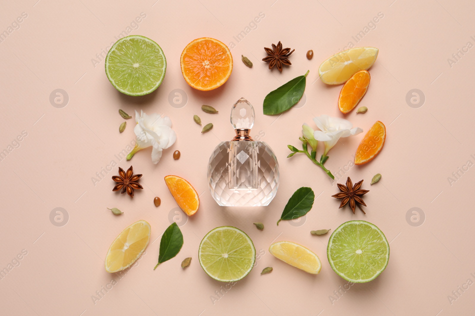 Photo of Flat lay composition with bottle of perfume, citrus fruits and flowers on pink background
