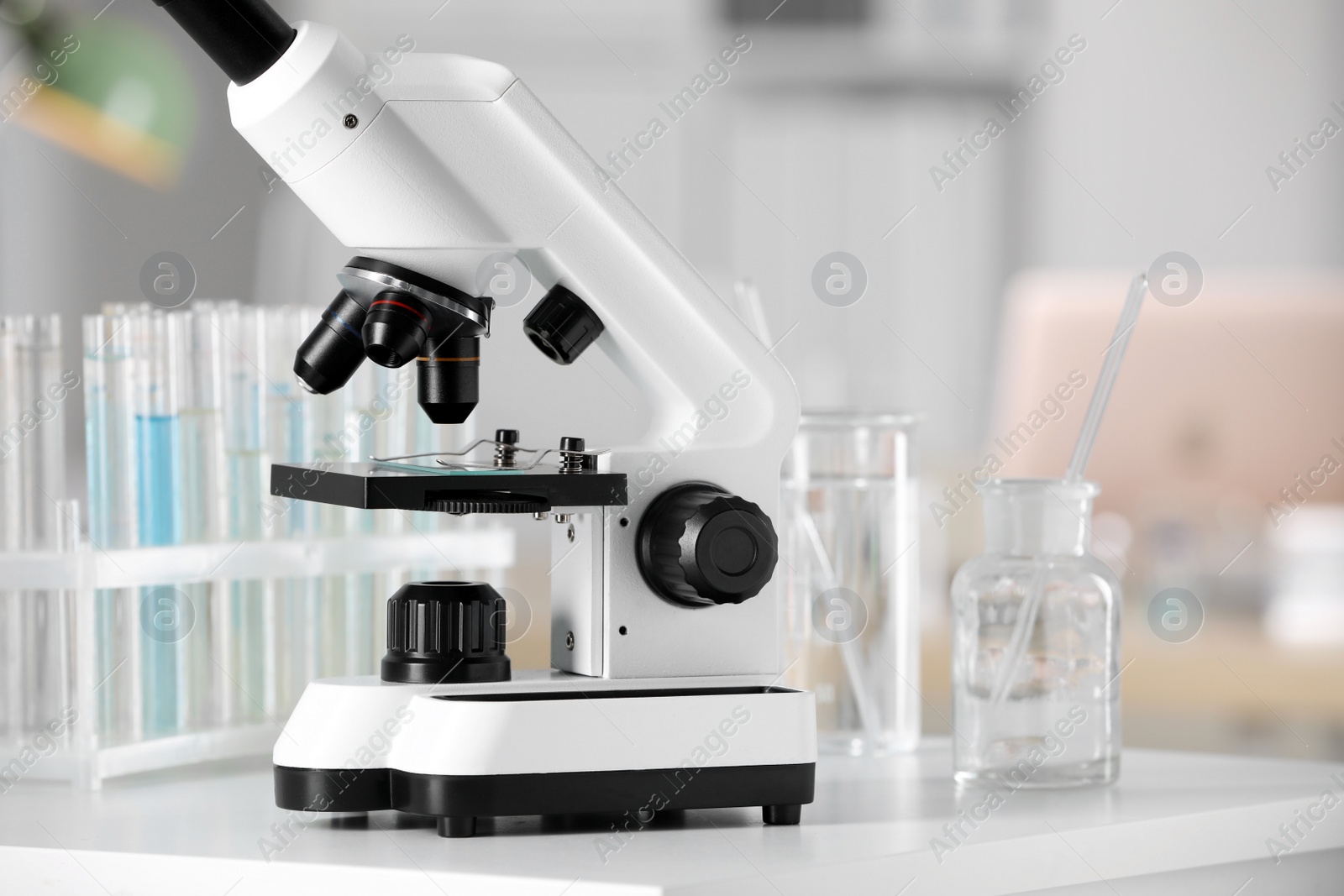 Photo of Modern medical microscope on white table in laboratory