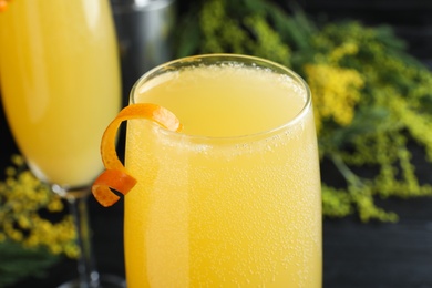 Glass of Mimosa cocktail with garnish on table, closeup