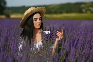 Beautiful young woman with bouquet in lavender field