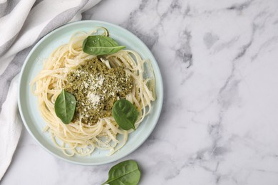 Photo of Tasty pasta with spinach, cheese and sauce on white marble table, top view. Space for text