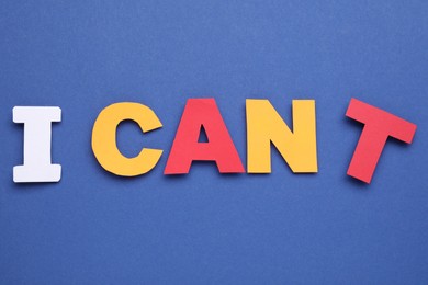 Photo of Motivation concept. Changing phrase from I Can't into I Can by removing paper letter T on blue background, top view