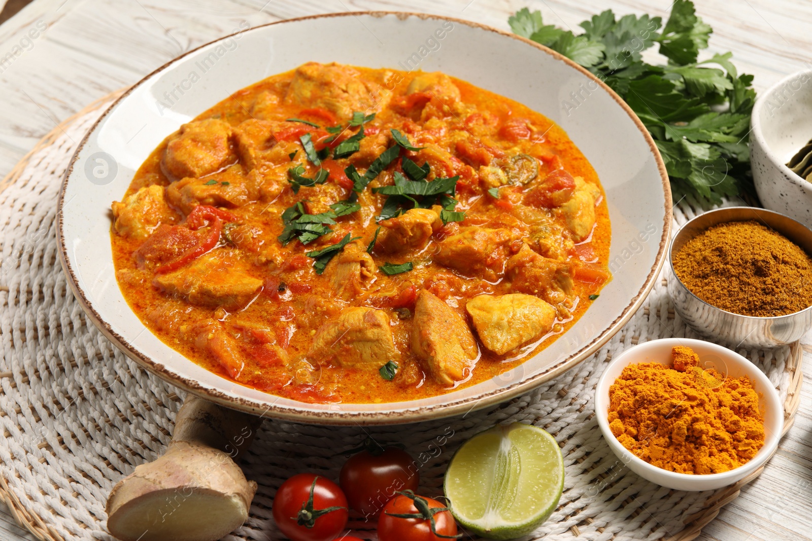 Photo of Delicious chicken curry and ingredients on table