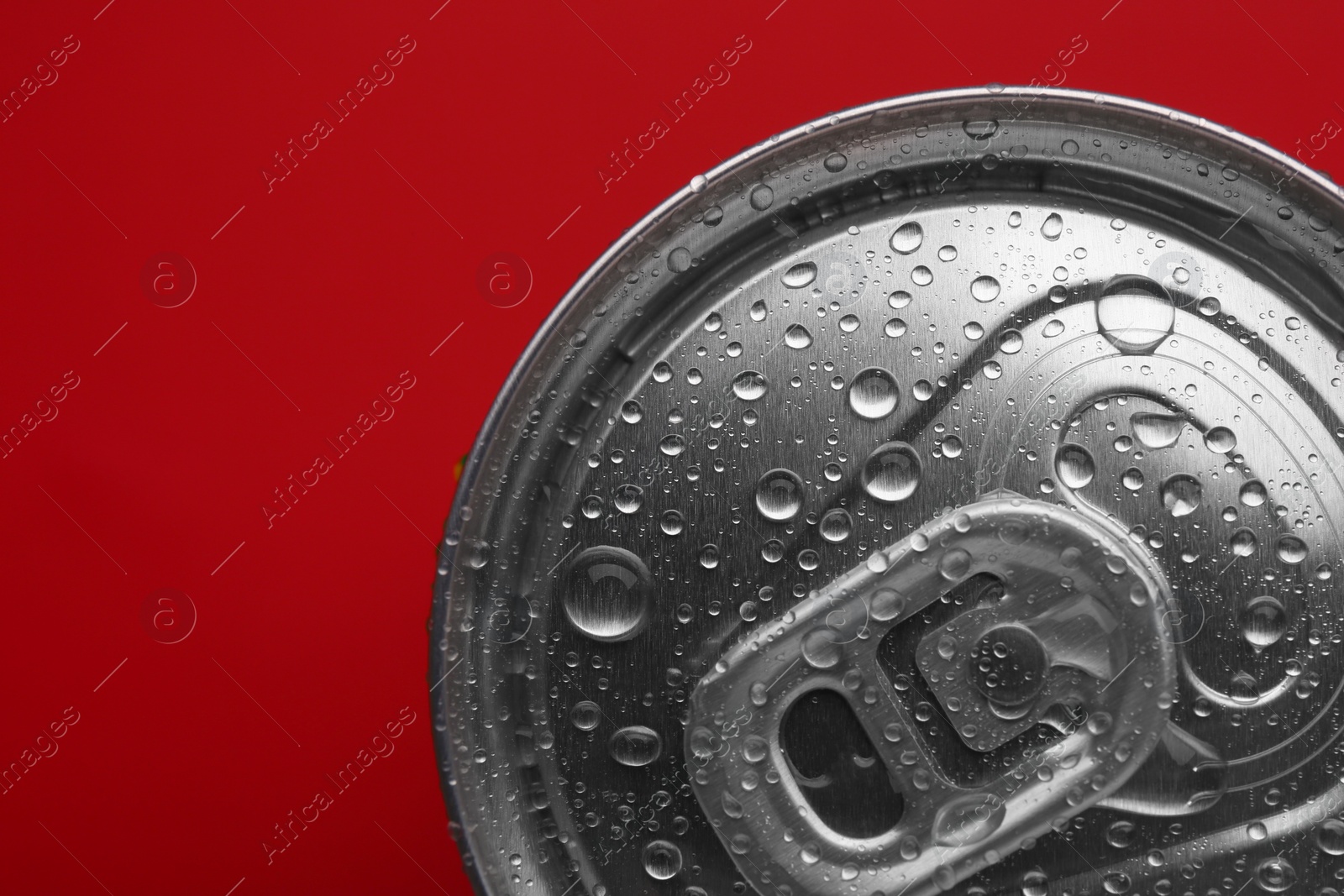 Photo of Energy drink in wet can on red background, top view. Space for text