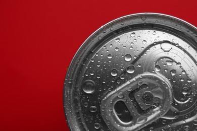 Photo of Energy drink in wet can on red background, top view. Space for text