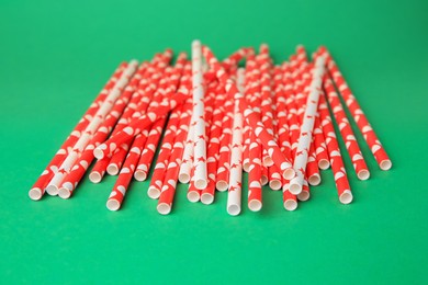 Photo of Many paper colorful drinking straws on green background