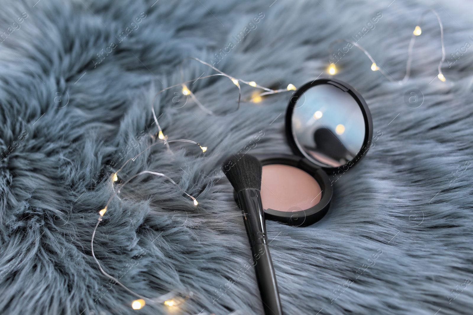 Photo of Makeup brush and powder on faux fur