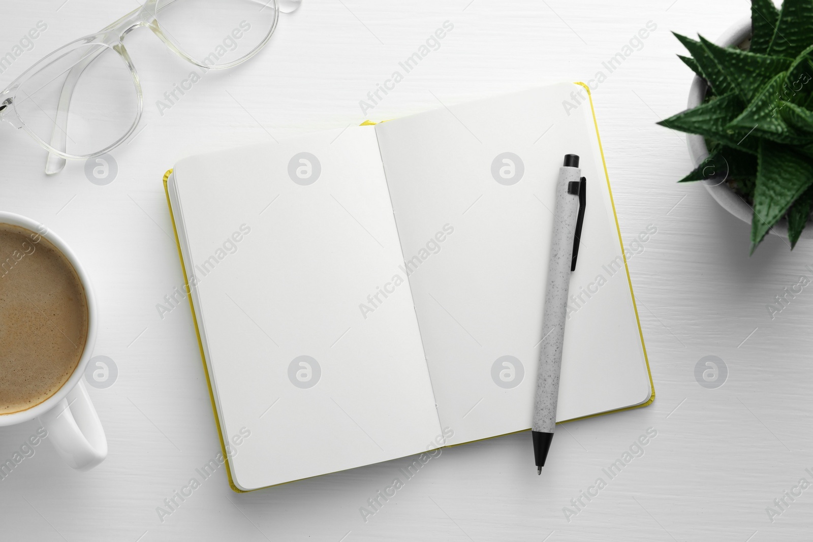 Photo of Open notebook, pen, glasses, succulent and cup of coffee on white wooden table, flat lay. Space for text