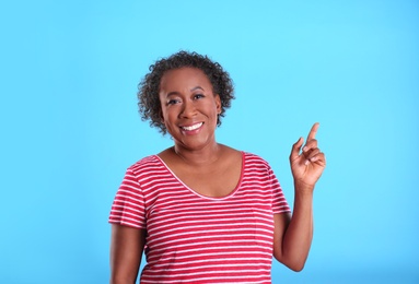 Photo of Portrait of happy African-American woman on light blue background