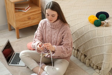 Photo of Woman learning to knit with online course at home, space for text. Handicraft hobby