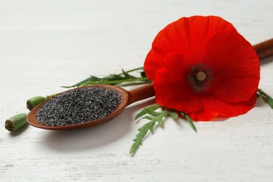 Photo of Composition with poppy seeds and flower on wooden table
