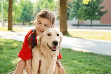 Cute little child with his pet in green park