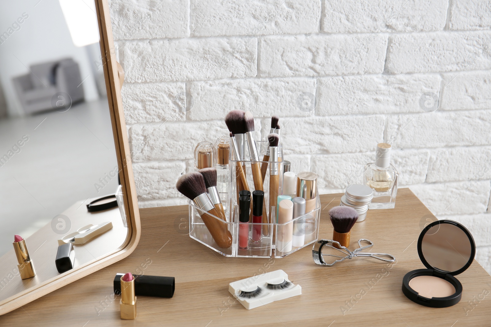 Photo of Makeup cosmetic products and tools on dressing table