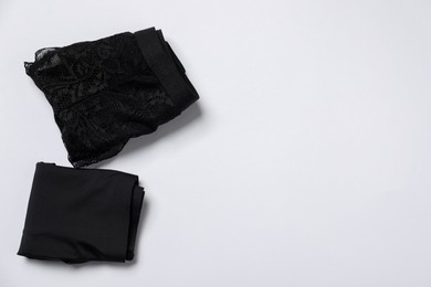 Photo of Stylish folded black women's underwear on white background, flat lay. Space for text