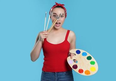 Woman with painting tools on light blue background. Young artist