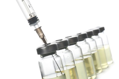 Photo of Syringe with vials of medicine on white background, closeup