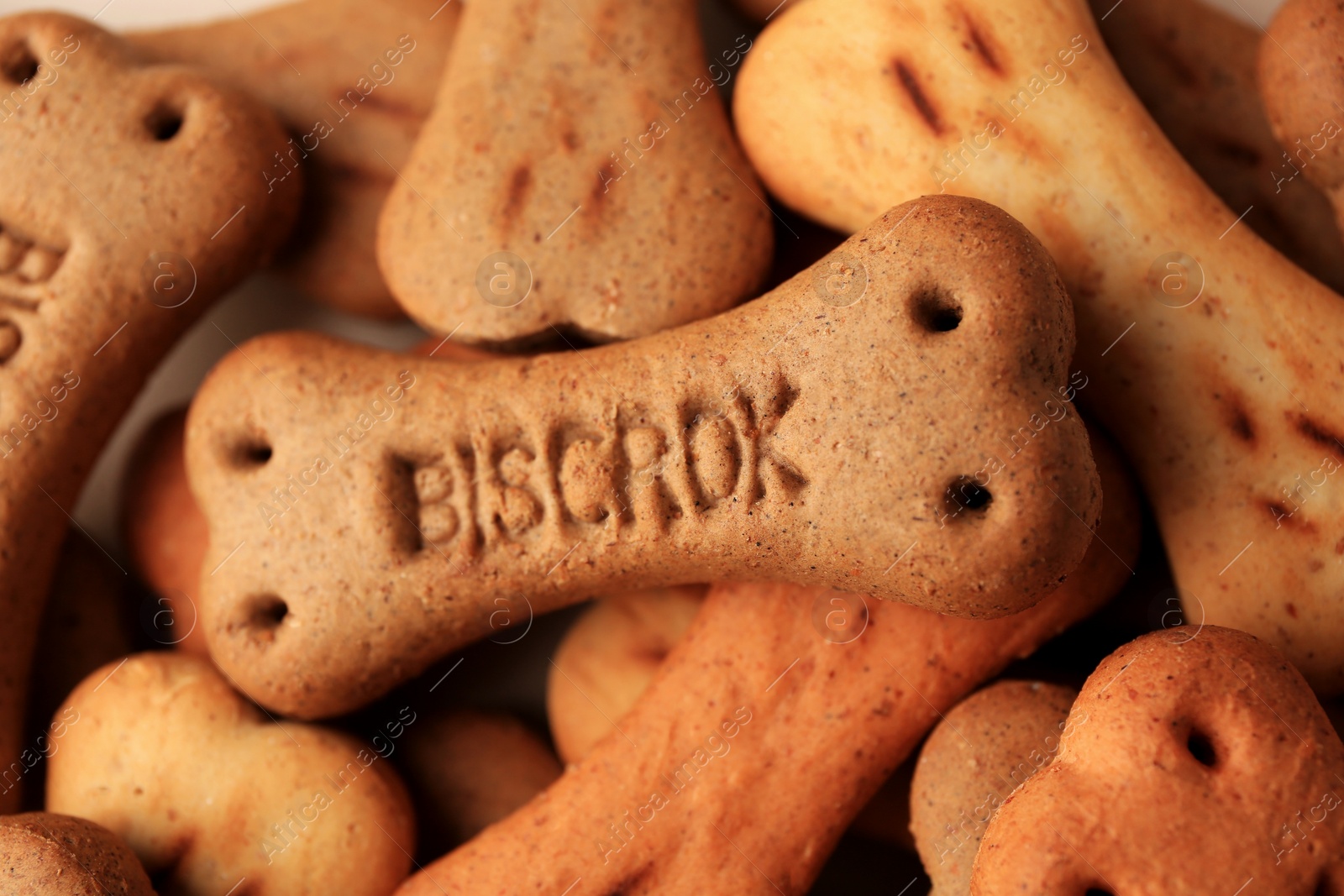 Photo of Heap of bone shaped dog cookies as background, closeup