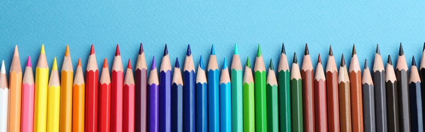 Image of Flat lay composition with color pencils on blue background. Banner design