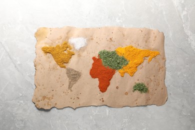 World map of different spices on light grey marble table, top view