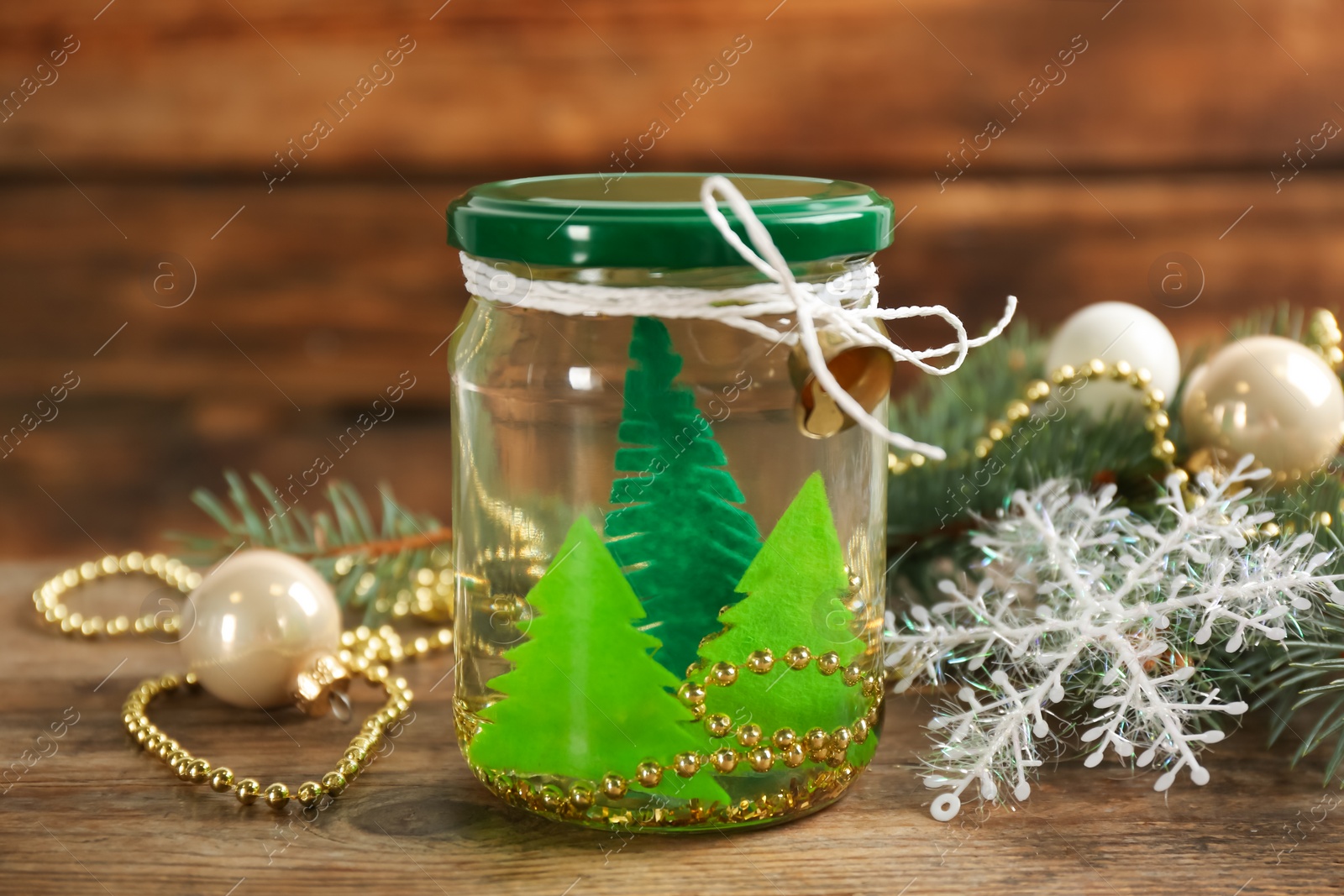 Photo of Handmade snow globe and Christmas decorations on wooden table, closeup