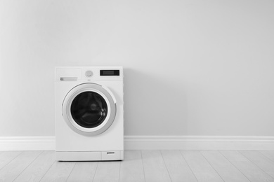 Photo of Washing machine near white wall, space for text. Laundry day