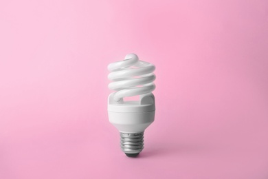 Photo of New fluorescent lamp bulb on pink background