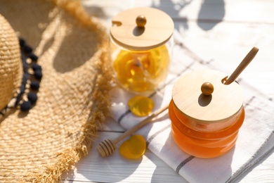 Composition with glass jar of fresh rose honey on white wooden table. Space for text