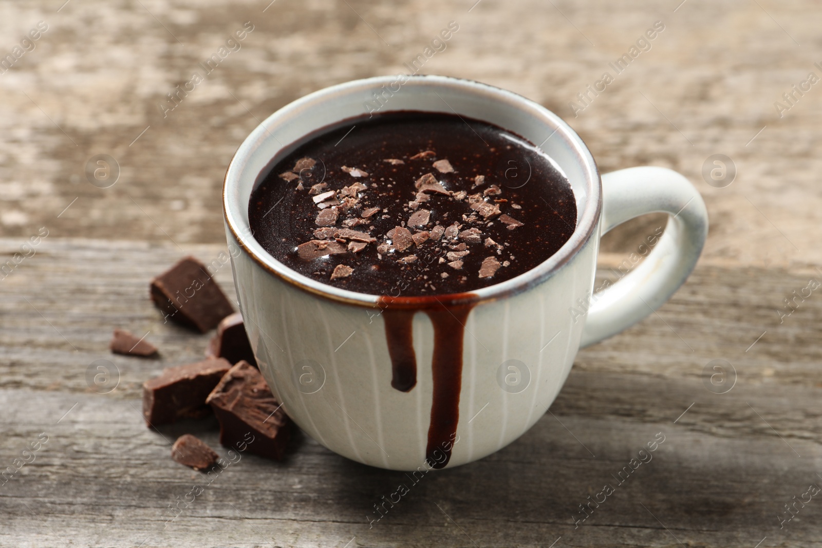 Photo of Yummy hot chocolate in cup on wooden table