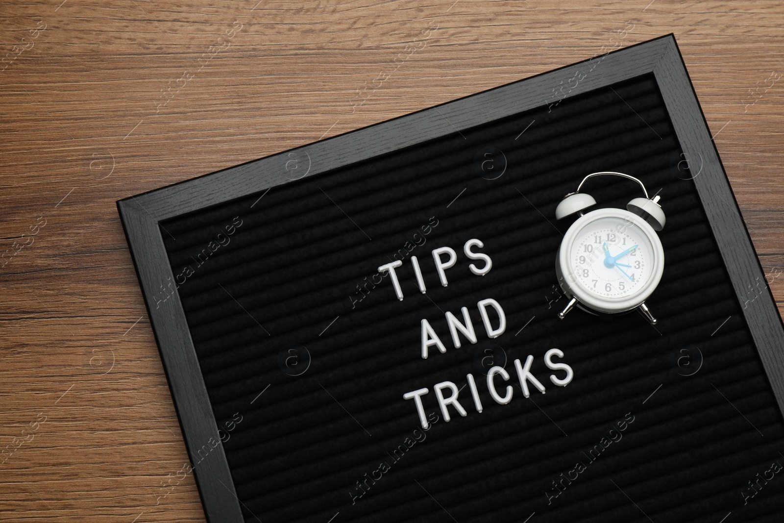 Photo of Black letter board with phrase Tips and Tricks on wooden table, top view