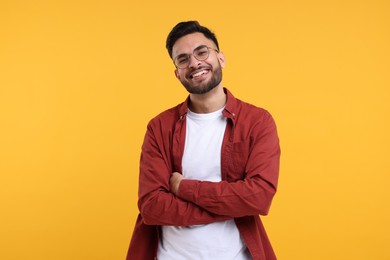 Photo of Handsome young man laughing on yellow background